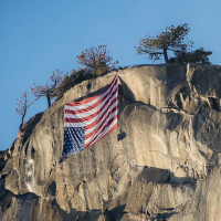 An upside-down U.S. flag hangs as a protest at Yosemite's El Capitan.