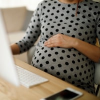 Pregnant woman working in office. 