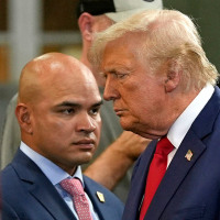 Donald Trump walks past aide Walt Nauta at a campaign event 