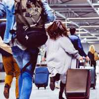 Passengers with luggage in airport corridor