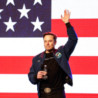 Elon Musk waves to supporters 