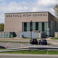 The exterior of Westhill High School from a distance across a parking lot and street