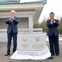 Two officials applauding at the ceremony for the construction of a bridge between North Korea and Russia