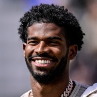  Shedeur Sanders smiling during a ceremony to retire his jersey 