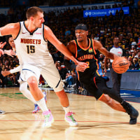 Shai Gilgeous-Alexander of the Oklahoma City Thunder dribbles against Nikola Jokic of the Denver Nuggets