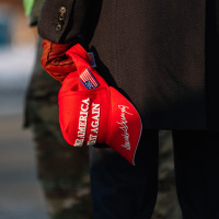 A Trump supporter holding a MAGA hat 
