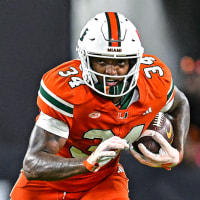 Adarius Hayes, center, runs with the football on the field