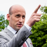 Stephen Miller points while speaking, stands outside