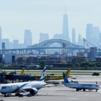 The New York City skyline is seen behind Newark Liberty International Airport, planes on the tarmac in foregound