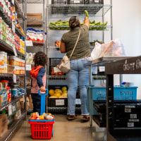 A child carries a basket of food at a food bank.