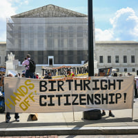 Image: People hold banners and signs as they participate in a protest outside the Supreme Court