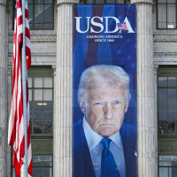 Ali Velshi; a banner showing an image of President Donald Trump hangs on the side of a U.S. Department of Agriculture building.