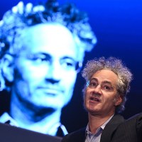 Alex Karp gestures while speaking.