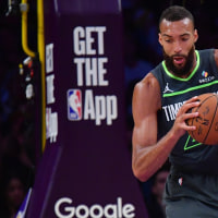 Apr 30, 2025; Los Angeles, California, USA; Minnesota Timberwolves center Rudy Gobert (27) gets the ball against Los Angeles Lakers guard Luka Doncic (77) during the first half in game five of first round for the 2025 NBA Playoffs at Crypto.com Arena. Mandatory Credit: Gary A. Vasquez-Imagn Images