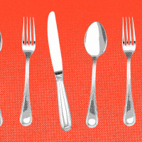 Forks, knives, and spoons lined up against a red background.