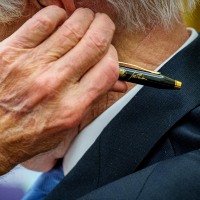 Joe Biden with a pen bearing his signature