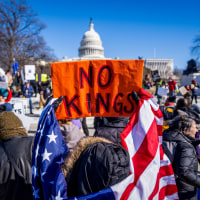 Demonstrators hold signs during the No Kings Day.