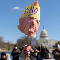 A protester holds up a Trump mask at the Presidents Day "No Kings" protest on Feb. 17, 2025, in Washington.