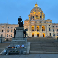 The exterior of the Minnesota State Capitol with a memorial in the front of the steps