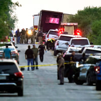 Police and other first responders work the scene where officials say dozens of people have been found dead and multiple others were taken to hospitals with heat-related illnesses after a tractor-trailer containing suspected migrants was found on June 27, 2022, in San Antonio. 