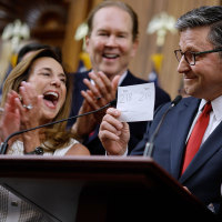 House Speaker  Mike Johnson holds up the final vote tally