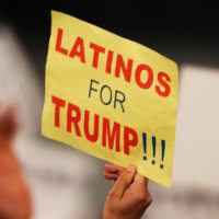 A supporter holds a sign that reads " Latinos for Trump"