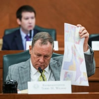Terry M. Wilson looks through maps during a public hearing