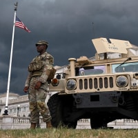 National Guard troops and a humvee next to Union Station, with American flags.