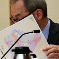Kevin Sparks looks at a copy of the proposed 2025-2026 redistricting map 