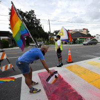 Activists rally at the Pulse Interim Memorial after repainting a rainbow-colored crosswalk on Friday, Aug. 22, 2025, in Orlando, Fla. 
