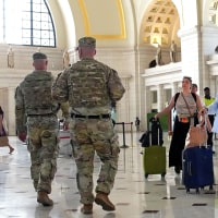 Travelers arrive alongside patrolling National Guard soldiers at Union Station on Aug. 25, 2025 in Washington, D.C. 