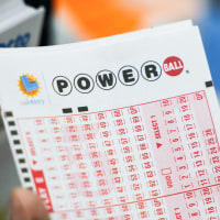 A hand holds a number slip lottery ticket