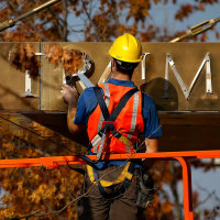 A worker removes the words "Trump Place" from a residential building in New York in 2016. 