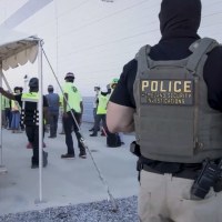 manufacturing plant employees being escorted outside the Hyundai Motor Group’s electric vehicle plant by officers