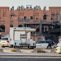 A man walks near a damaged building