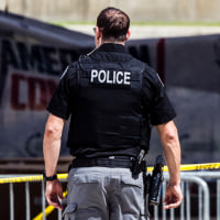 A police officer walks toward the crime scene tent