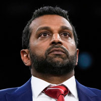 Kash Patel stands and raises a hand