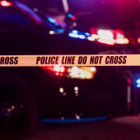 Two police officers behind crime scene tape