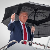 President Donald Trump gives a thumbs-up while boarding Air Force One 