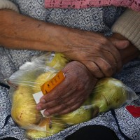 A woman holds a bag of pears as she waits in line to receive free food at the Richmond Emergency Food Bank.