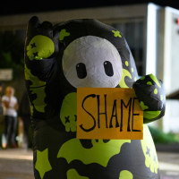 Jen Psaki; A protester in an inflatable suit holding a sign outside the U.S. Immigration and Customs Enforcement building.