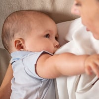 Mother breastfeeding a 6 month old baby boy.