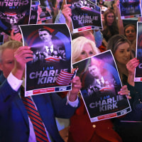 Attendees hold posters of late right-wing activist Charlie Kirk during a Turning Point USA.
