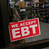 A store displays a sign accepting Electronic Benefits Transfer (EBT) cards for Supplemental Nutrition Assistance Program (SNAP) purchases.