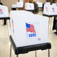 Voting booths and voters are seen on Election Day at a polling location.