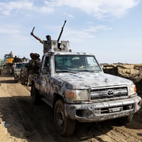 A Multinational Joint Task Force (MNJTF) military escort accompanying an excavator digging trenches passes through a checkpoint in Borno state, Nigeria.