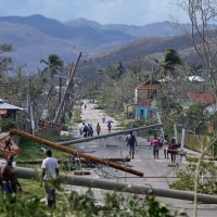 Residents walk through the aftermath of Hurricane Melissa in Jamaica.