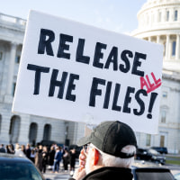 A protester holds a sign related to the release of the Jeffrey Epstein case files outside the Capitol.