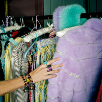 A person selects clothes from a rack.