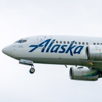 Image: Boeing 737-790 aircraft belonging to Alaska Airlines flying against a foggy white sky